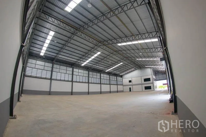 Warehouse for sale in Krathum Baen, Samut Sakhon - Wide high-clear warehouse hall with steel truss roof and skylights.
