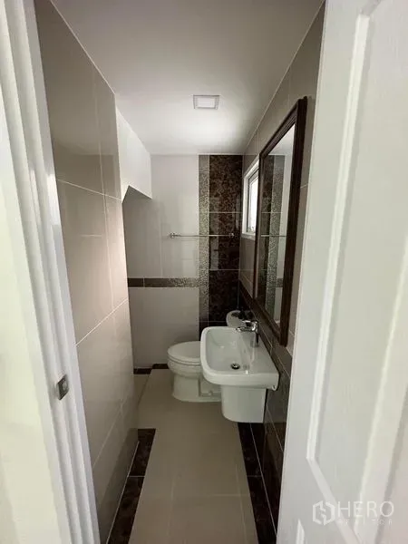 Detached House for rent - Compact bathroom with tiled walls, vanity, mirror, and toilet.