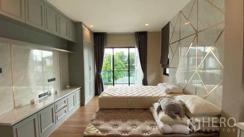 独立式住宅 出售在Khan Na Yao, Bangkok - 主卧带定制衣柜与特色墙，大窗可观绿意。