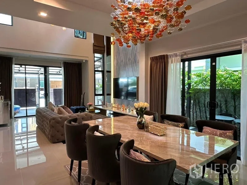 独立式住宅 出租在Prawet, Bangkok - 餐厅与客厅一体，个性吊灯，临近花园景观。