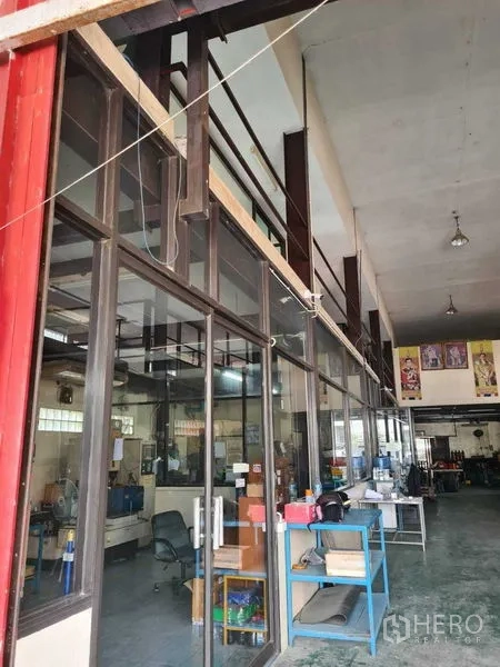 Warehouse for sale in Mueang Samut Prakan, Samut Prakan - High-ceiling warehouse interior with a glass-partitioned office, concrete floor, workbenches and bright lighting in Pak Nam, Samut Prakan.