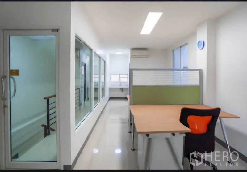 Home Office for rent or sale in Lat Krabang, Bangkok - Corridor with glass walls and desk area receiving natural light and air conditioning.