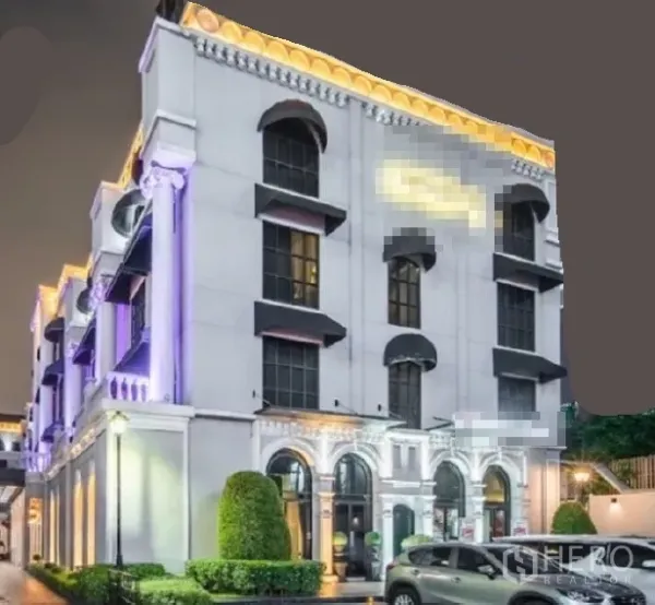 พื้นที่ขายปลีก ให้เช่าในHuai Khwang, Bangkok - อาคารพาณิชย์สไตล์นีโอคลาสสิกยามค่ำ แสงไฟโดดเด่น หน้าต่างโค้ง และที่จอดรถ ในย่านห้วยขวาง กรุงเทพฯ