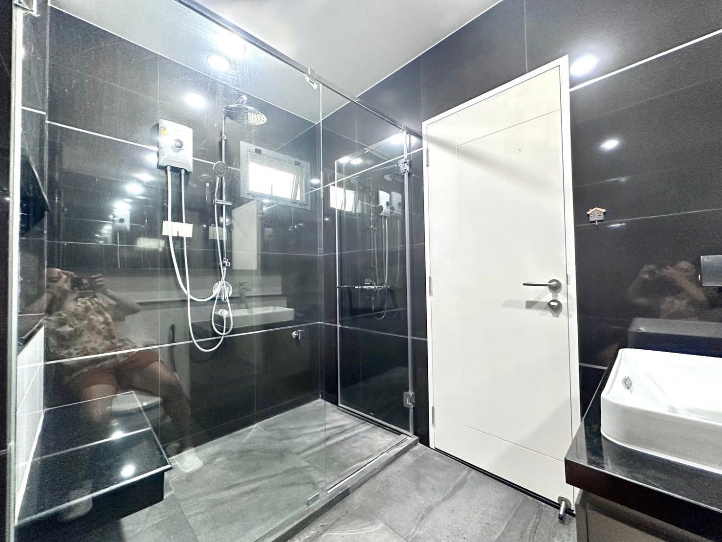 独立式住宅 出租在Bang Kapi, Bangkok - 现代化浴室，黑色瓷砖，玻璃淋浴间、雨淋花洒与台上盆。