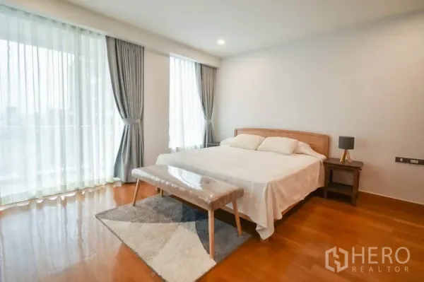 คอนโด ให้เช่าในPathum Wan, Bangkok - ห้องนอนใหญ่ เตียงคิงส์ไซส์ หน้าต่างบานใหญ่ ม่านนุ่มบนพื้นไม้