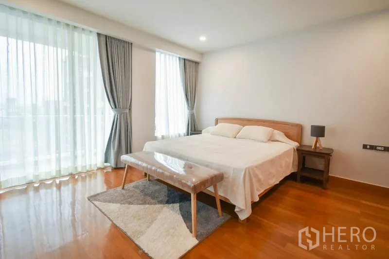 คอนโด ให้เช่าในPathum Wan, Bangkok - ห้องนอนใหญ่ เตียงคิงส์ไซส์ หน้าต่างบานใหญ่ ม่านนุ่มบนพื้นไม้