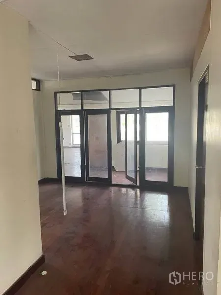 Detached House for rent in Suan Luang, Bangkok - Hallway with glass-panel doors leading to a bright room.