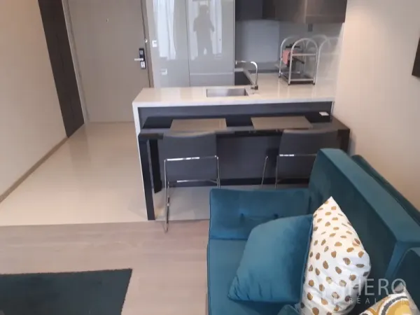 Condominium for rent or sale in Watthana, Bangkok - Cozy seating beside a breakfast bar with two stools and a stone-top island in a compact layout.