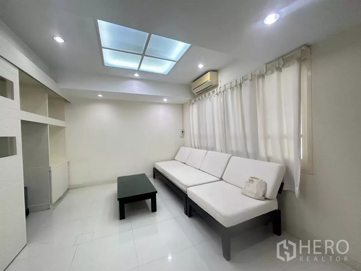 Detached House for rent in Suan Luang, Bangkok - Cozy family room with a long white sofa and skylight ceiling.