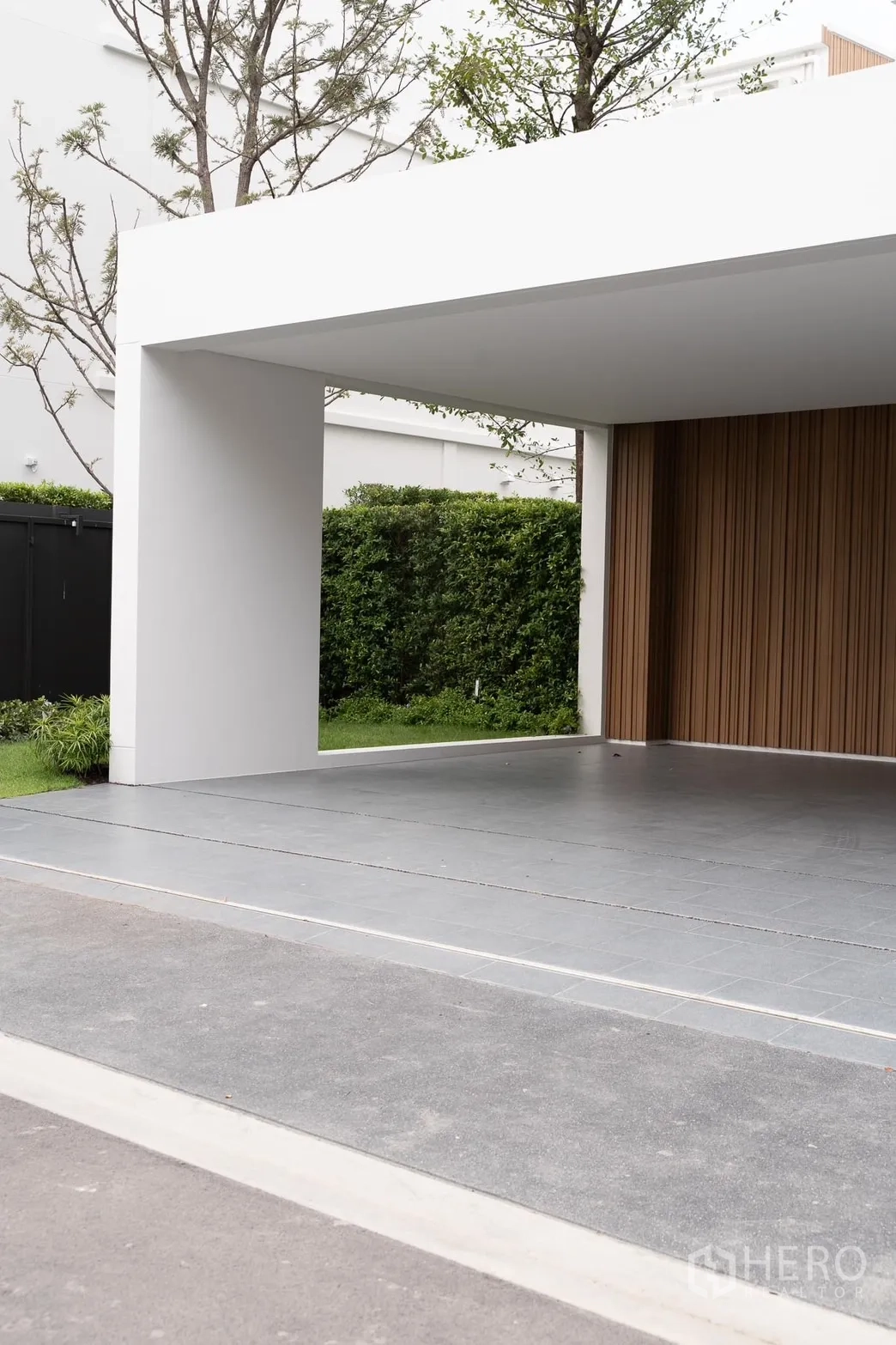 Detached House for rent in Saphan Sung, Bangkok - Spacious covered carport with minimalist white frame and wood accent wall