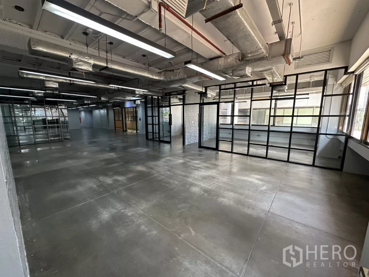 办公空间 出租 - 宽敞工作区，落地网格玻璃墙与线性LED照明。