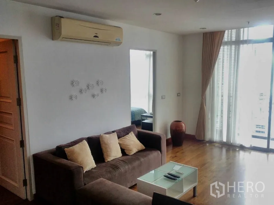 Condominium for rent in Watthana, Bangkok - Cozy lounge area with air-conditioner, glass coffee table and floor-to-ceiling windows