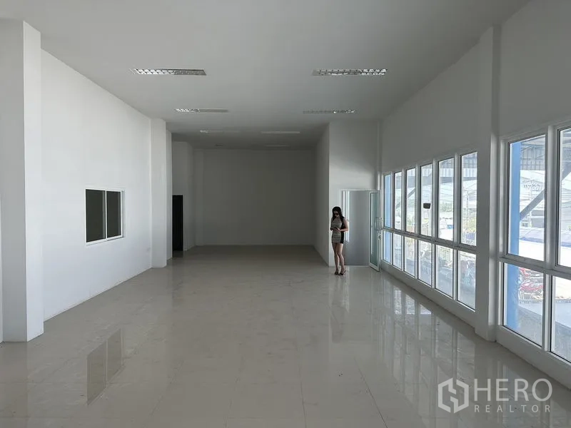 Factory for rent in Bang Bo, Samut Prakan - Large bright office or showroom with full-height windows and glossy tiled flooring.
