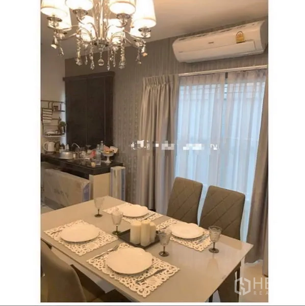 联排别墅 出租在Bang Kapi, Bangkok - 餐区配水晶吊灯，四人餐桌，推拉玻璃门通向阳台。