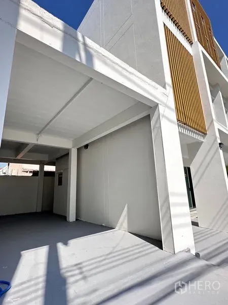 Home Office for sale in Lat Krabang, Bangkok - Modern white multi-storey home office facade with vertical wood screens and covered parking area.