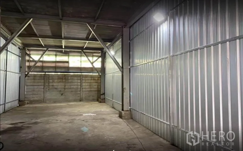 Warehouse for rent in Phra Samut Chedi, Samut Prakan - Steel-frame warehouse interior with metal cladding, concrete floor and roof skylight panels in Samut Prakan.
