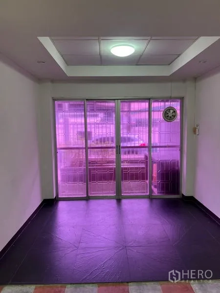 Townhouse for rent in Khlong Toei, Bangkok - Close view of sliding glass doors with security grilles and purple-tinted panels.