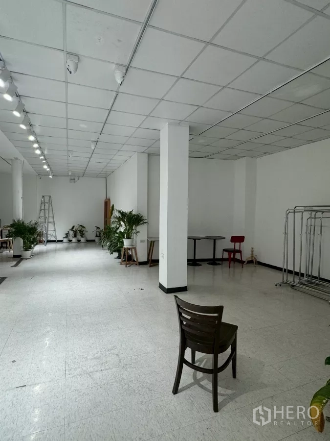 Shophouse for rent in Samphanthawong, Bangkok - Retail hall perspective showing columns, ladder and display space.