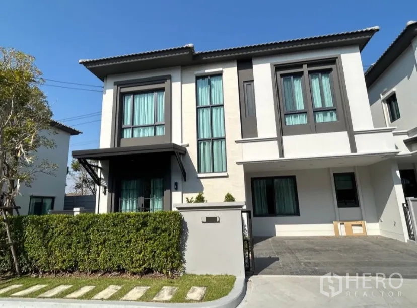 บ้านแฝด for rent in Bang Phli, Samut Prakan - ภาพภายนอกบ้านแฝดสองชั้นสมัยใหม่ พร้อมรั้วพุ่มและทางเข้าจอดรถ