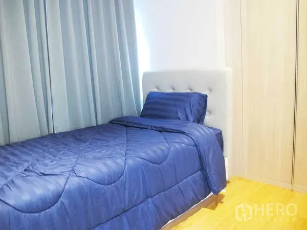 คอนโด ให้เช่าในWatthana, Bangkok - ห้องนอนรอง เตียงเดี่ยวผ้าปูสีน้ำเงิน ม่านสูง และตู้เสื้อผ้าบิวท์อิน