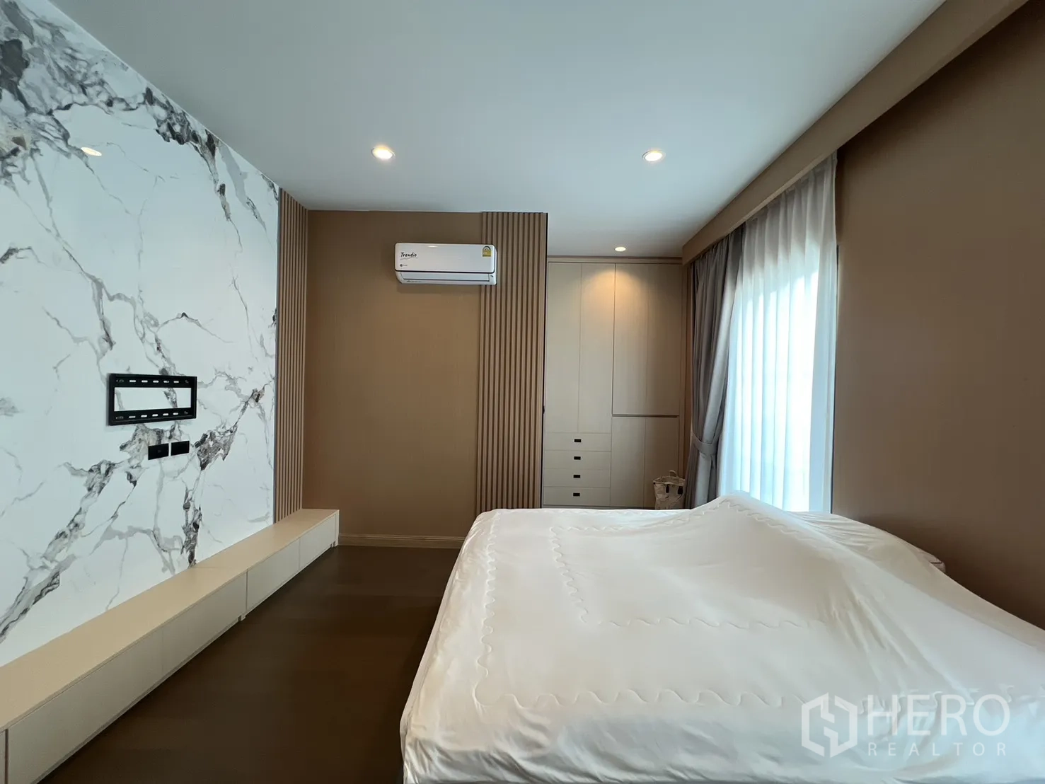 Detached House for rent or sale in Mueang Pathum Thani, Pathum Thani - Secondary bedroom with marble feature wall and fitted cabinetry.