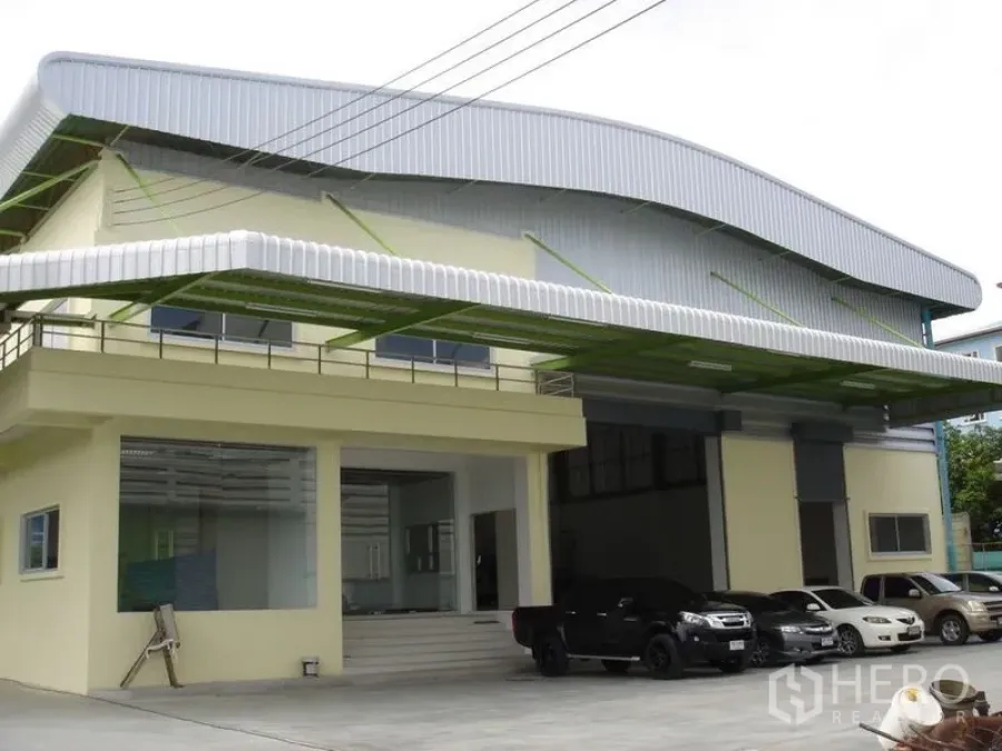คลังสินค้า ให้เช่าในLat Krabang, Bangkok - ด้านหน้าโกดังพร้อมประตูม้วนคู่ หลังคากันสาด และลานจอดรถในพื้นที่