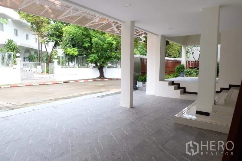 Detached House for sale in Bang Phli, Samut Prakan - Covered carport with tiled floor and pillars facing a quiet residential street.