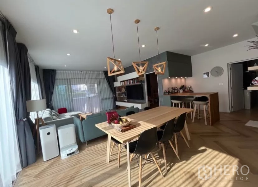Detached House for rent in Prawet, Bangkok - Dining area with geometric pendant lights connected to the lounge and large windows.