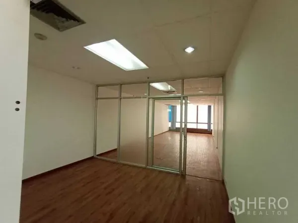 Office Space for rent - Private office divided by frosted glass panels under LED lighting.