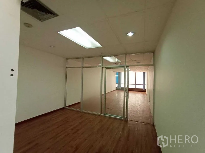Office Space for rent - Private office divided by frosted glass panels under LED lighting.