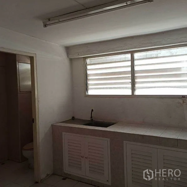 อาคารพาณิชย์ ให้เช่าในKhlong Toei, Bangkok - มุมแพนทรีเรียบง่าย มีซิงก์ หน้าต่างบานเกล็ด และห้องน้ำติดกัน