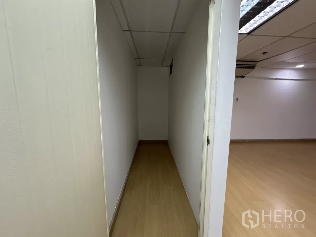Office Space for rent in Watthana, Bangkok - Narrow storage room with wood flooring and plain white walls.