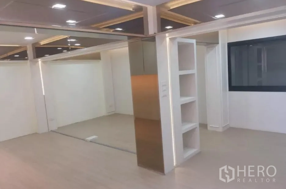 พื้นที่ขายปลีก ให้เช่า - โซนโชว์รูมสว่าง มีชั้นบิลท์อินและหน้าต่างกรอบอลูมิเนียม