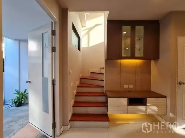 ทาวน์เฮาส์ ให้เช่าในKhlong Toei, Bangkok - โถงบันไดพร้อมตู้บิลท์อินและไฟส่อง พื้นที่เชื่อมต่อไปยังลานด้านนอก