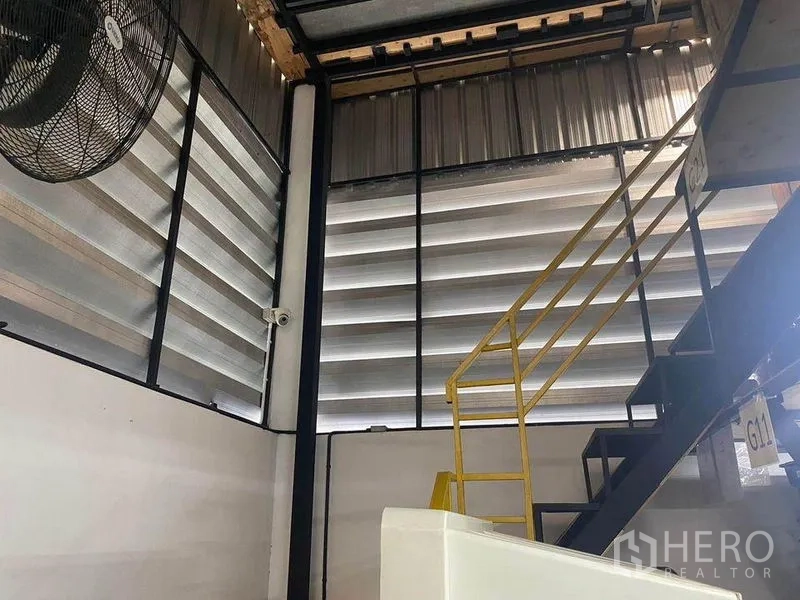 สำนักงานที่บ้าน ให้เช่าหรือขายในBang Khae, Bangkok - บันไดโลหะขึ้นชั้นลอยข้างช่องระบายอากาศบานเกล็ดภายในโกดัง