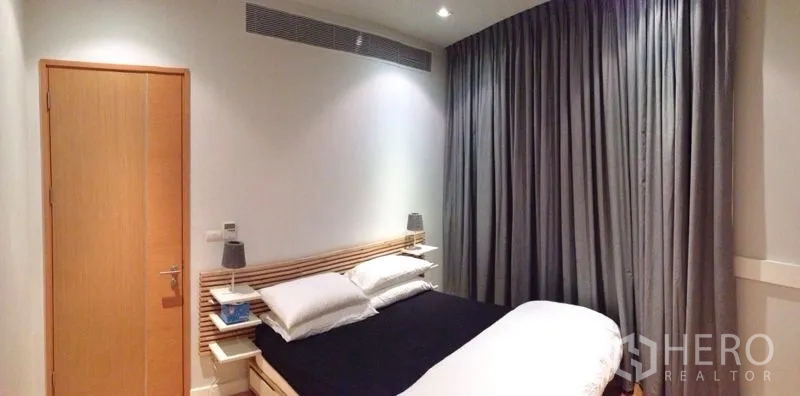 公寓 出租在Ratchathewi, Bangkok - 温馨卧室，双人床、床头灯与落地遮光窗帘。