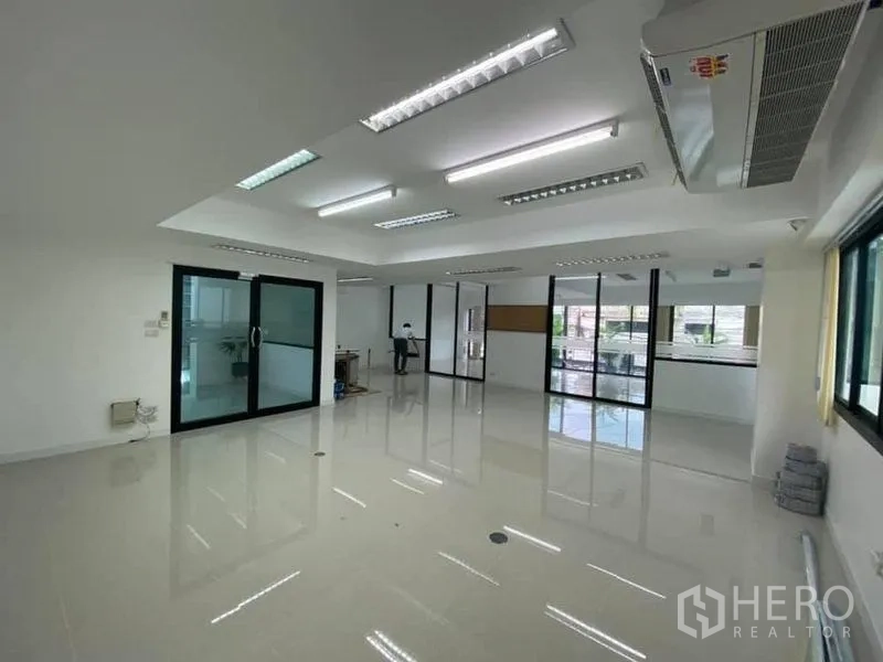 Office Space for rent in Suan Luang, Bangkok - Large office room with windows, glass doors and polished tile floor.