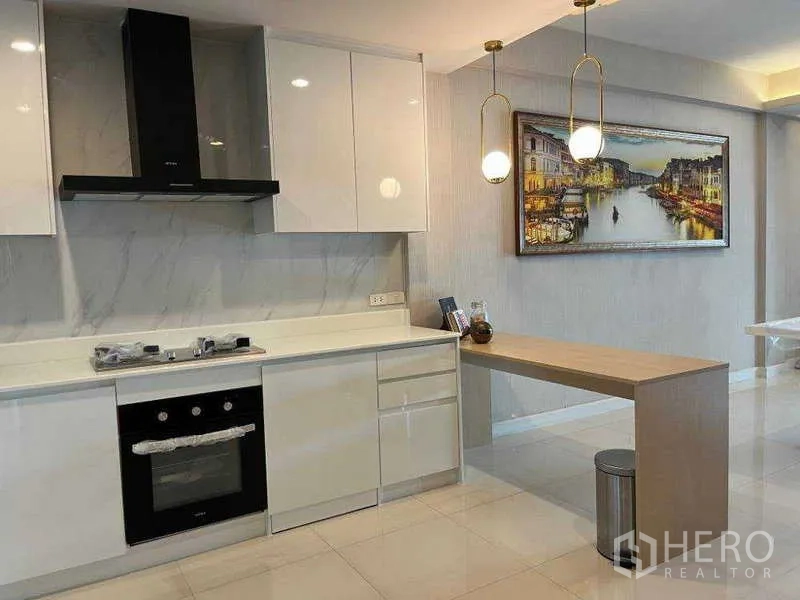 ทาวน์เฮาส์ ให้เช่าในKhlong Toei, Bangkok - ครัวสไตล์โมเดิร์นสีขาว ตั้งเตาอบ เตา และเคาน์เตอร์บาร์ใต้โคมไฟแขวน