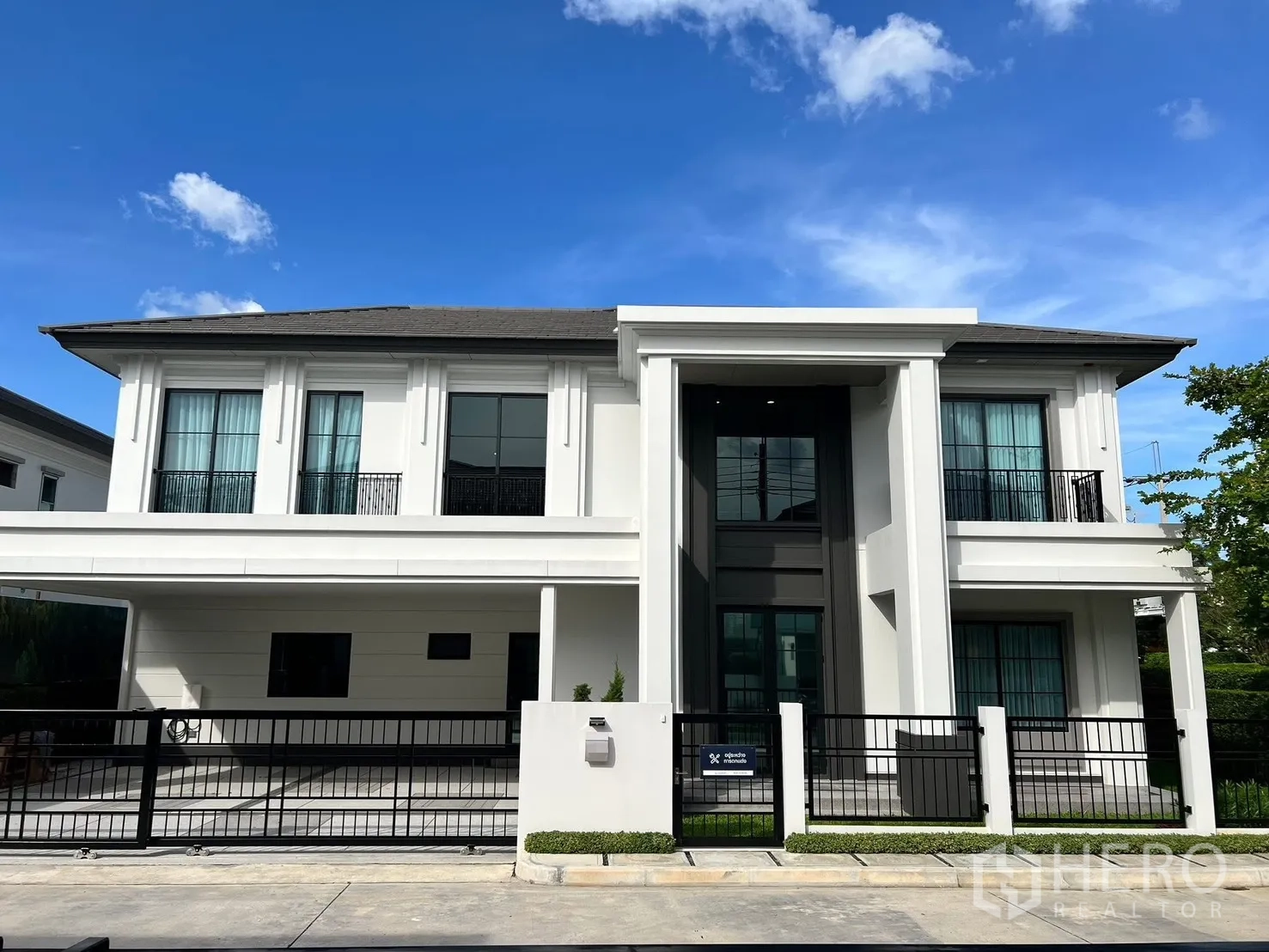 独立式住宅 出租在Bang Phli, Samut Prakan - 现代两层独栋外观，带栅栏车道与露台窗。