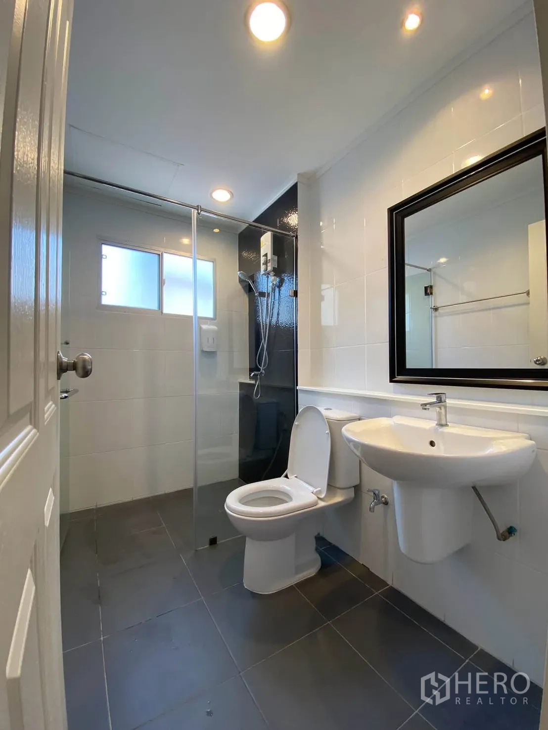 Detached House for rent in Mueang Samut Prakan, Samut Prakan - Modern bathroom with glass shower enclosure, sink, and toilet.