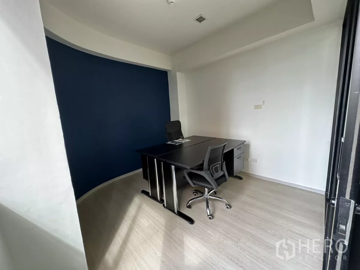 Office Space for rent in Watthana, Bangkok - Compact executive office with a black workstation and curved navy feature wall.