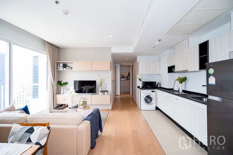 公寓 出租在Watthana, Bangkok - 开放式客厅，电视柜与走廊式厨房布局。