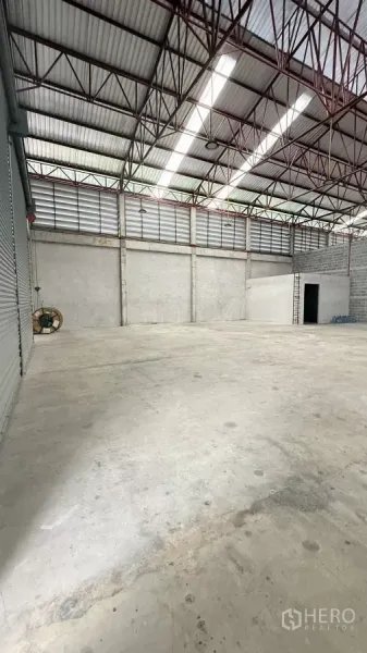 Warehouse for rent in Min Buri, Bangkok - View from the roller shutter side highlighting ventilated louvers, high-bay lights and open floor.