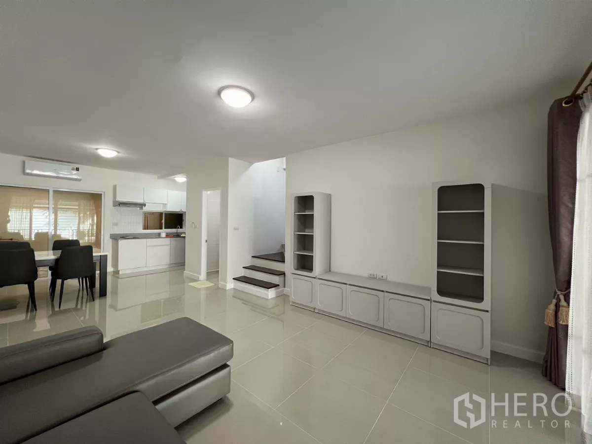 Townhouse for rent in Bang Kapi, Bangkok - Living area with built-in shelves and stairs to upper floors.