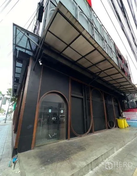 อาคารพาณิชย์ ให้เช่า - หน้าตึกติดถนน มีกันสาดและประตูกระจกทรงโค้ง
