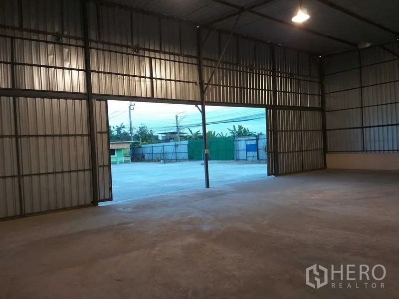 คลังสินค้า ให้เช่าในKhlong Sam Wa, Bangkok - มุมมองจากในโกดังผ่านประตูบานใหญ่ไปยังลานที่ปลอดภัย