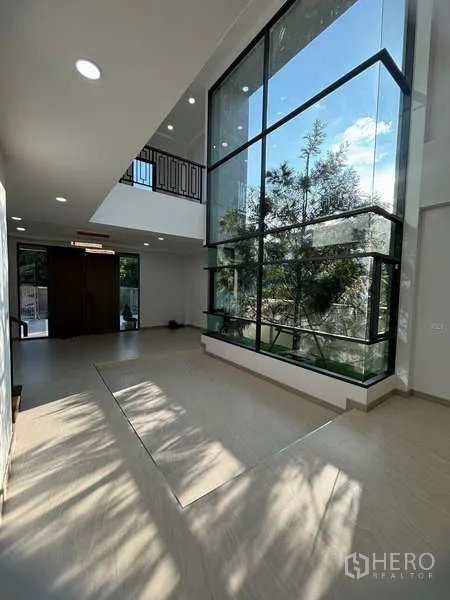 Detached House for rent or sale in Suan Luang, Bangkok - Double-height foyer with floor-to-ceiling corner glass bringing garden views inside