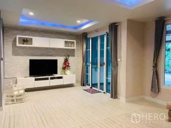 Detached House for sale in Din Daeng, Bangkok - TV wall with built-in cabinets and sliding doors opening to the terrace.