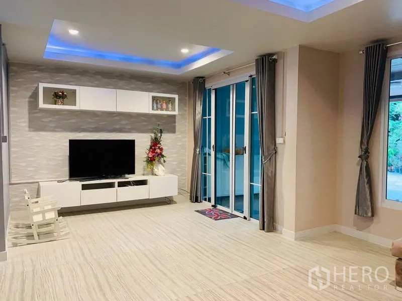 Detached House for sale in Din Daeng, Bangkok - TV wall with built-in cabinets and sliding doors opening to the terrace.