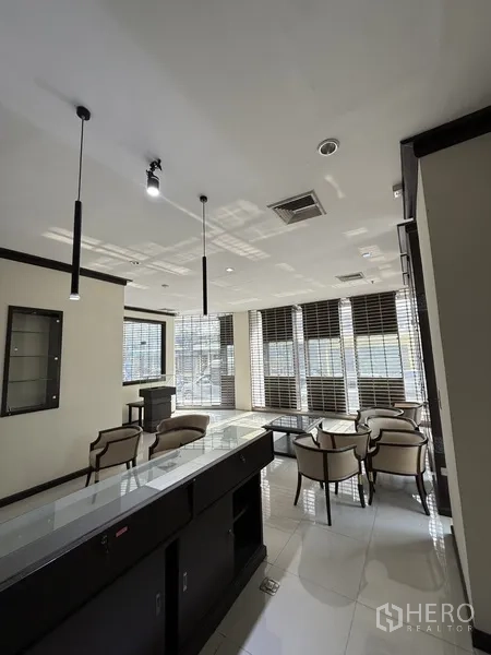 零售空间 出租在Sathon, Bangkok - 靠近大窗与百叶的顾客休息区，配吊灯与展示台。